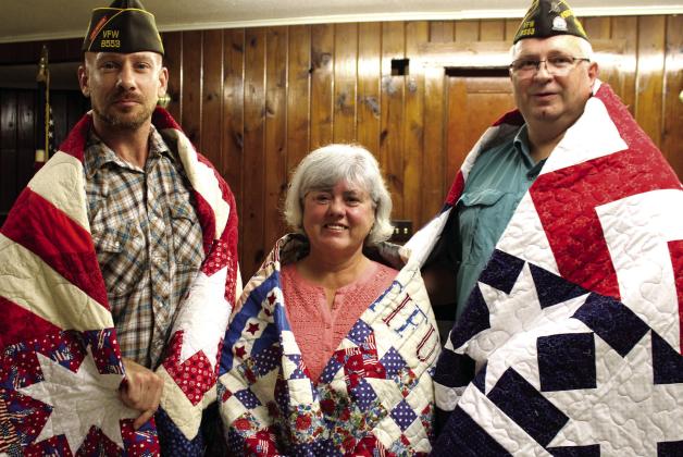 Three more Bosque County Veterans were awarded Quilts of Valor by local quiltmaker and volunteer Debbie Stubbs at the VFW Hall in Clifton Thursday evening. From left is Stephen Cariotis, Becky Cano and Ricky Richards wrapped in their quilts. Ashley Barner | The Clifton Record