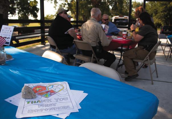 Sheriff Trace Hendrics and his deputies sit down for supper for first responders Thursday night at the Chisholm Trail Plaza in Meridian, part of the city’s appreciation cookout event. Allen D. Fisher | Meridian Tribune