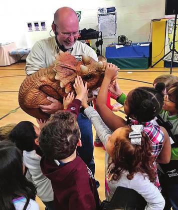 Dinosaur George Blasing volunteers many hours traveling to elementary schools to teach kids about dinosaurs and other prehistoric life. The traveling exhibit comes to Clifton Elementary School on Tuesday, Feb. 22. Photo Courtesy of Dinosaur George