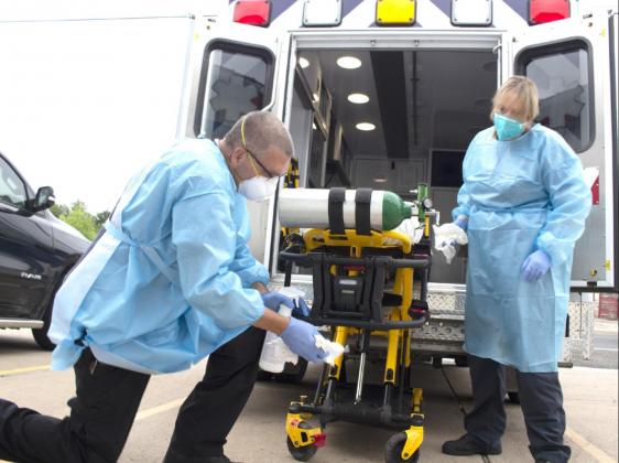 Allen D. Fisher | Meridian Tribune Medics with Bosque County EMS clean the ambulance and stretcher in full PPE gear last week at the EMS station in Meridian.