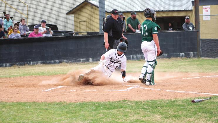 Brayden Wehmeyer slides into home, adding another run to the scoreboard for the Meridian Yellowjackets. Brook DeZavala | Meridian Tribune