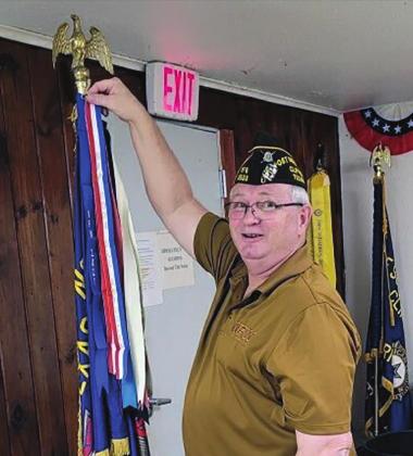 Courtesy Photo VFW Post 8553 Commander Ricky Richards attaches the All-American Streamer to the Post flag during the monthly meeting on Oct. 7.
