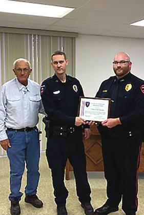 Brook DeZavala | The Clifton Record Clifton Police Corporal Cody Woosley (middle) is presented with the Life Saving Award by Mayor Richard Spitzer (left) and Interim Police Chief Gage Guinn (right) at the Tuesday, Dec. 14 City Council meeting.