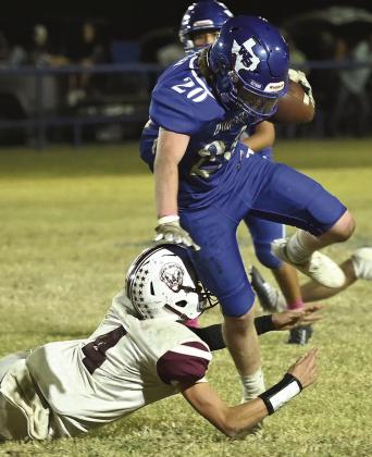 Walnut Springs freshman Ashton Shuemake hurdles defender. Photo courtesy of Brett Voss’ The Sports Buzz
