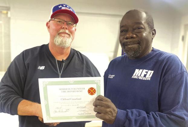 Meridian Volunteer Fire Department Chief Kevin Brister (from left) hands Clifford Crawford a certificate recognizing his volunteer service for responding to the most calls (101 of 142) in 2022. Courtesy Photo by Meridian Volunteer Fire Department