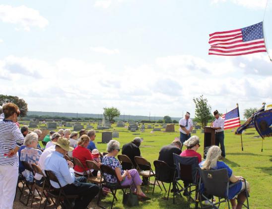 A patriotic crowd gathers at Clifton Cemetery for the annual Memorial Day ceremony hosted by American Legion Post 322 and VFW Post 8553. At the podium, VFW Chaplain Stephen Cariotis gives the opening prayer while VFW Commander Ricky Richards stands by. Ashley Barner | Meridian Tribune