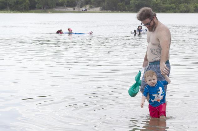 Chis Neal plays with his son, Jack, along the shores of Meridian Lake Saturday during July 4th. Allen D. Fisher | The Clifton Record