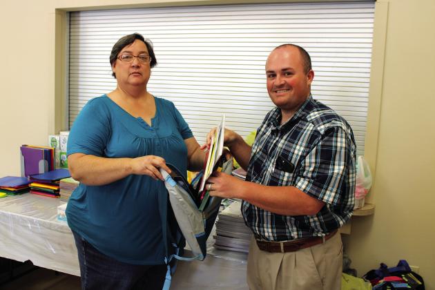 Meridian City Council member Sharon Wilson and Meridian Mayor Ryan Nieuwenhuis show off an abundance of school supplies donated by local churches, businesses and individuals for the Back to School Bash, taking place in Meridian’s parks Saturday from 4 to 8 p.m. Ashley Barner | Meridian Tribune